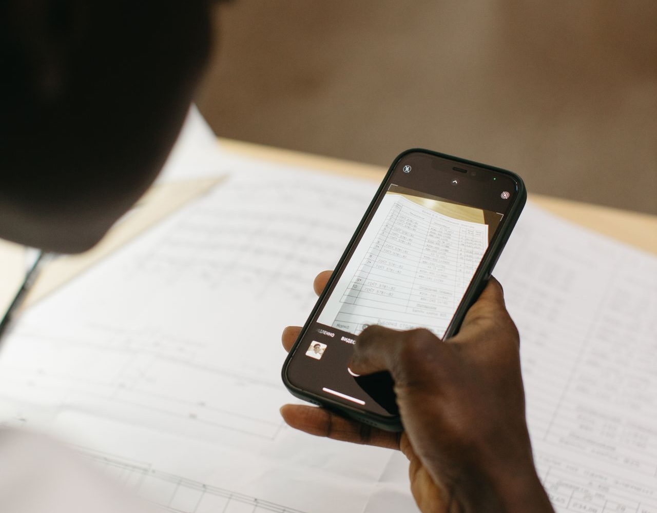 a person photographing a paper maintenance record with their phone to save a digital copy