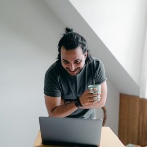 Happy man using laptop near carton box