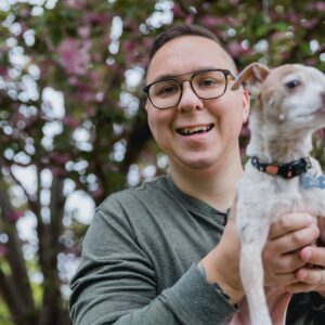 a man holding a small dog in his hands