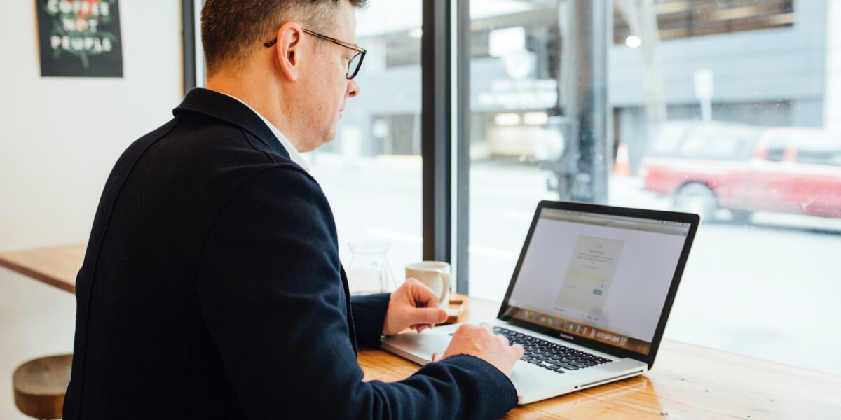 man wearing blue suit in front of MacBook Pro